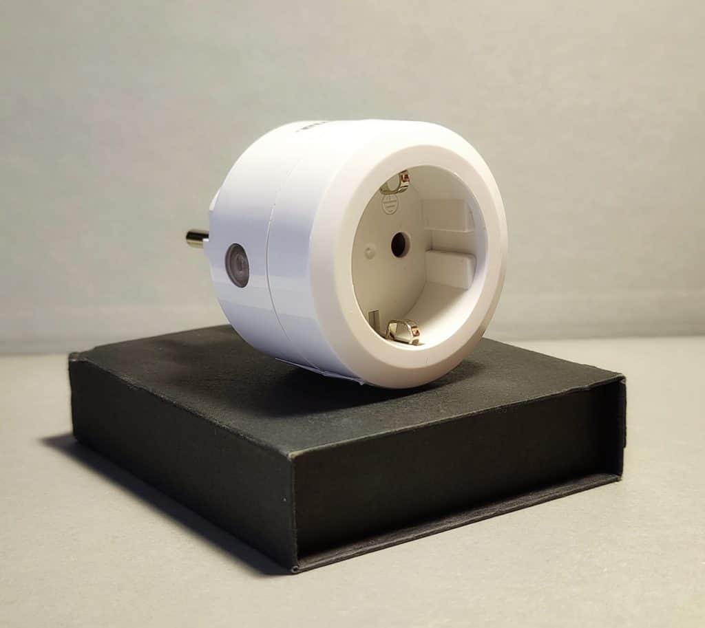 Weißer Smart-Home-Stecker auf einer schwarzen Verpackung, geeignet für die Steuerung elektrischer Geräte.