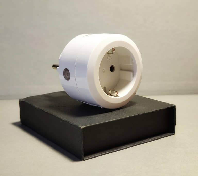 Weißer Smart-Home-Stecker auf einer schwarzen Verpackung, geeignet für die Steuerung elektrischer Geräte.