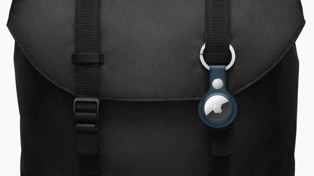 Apple AirTag-Halterung in Blau am schwarzen Rucksack mit robusten Trägern, sichtbar neben dem Apple-Logo auf dem Metallchip, betont durch dunkle Stoffstruktur
