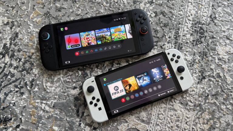 Zwei Nintendo Switch Konsolen, eine schwarze Joy-Con-Variante und eine weiße, liegen auf einem gemusterten Teppich; Displays zeigen bunte Spielkacheln und Menüsymbole