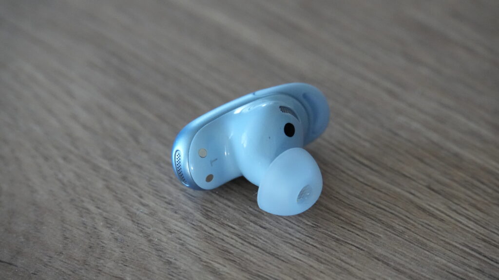 Hellblaue Soundcore Liberty 5 Pro liegen auf einer Holzoberfläche und zeigen das kabellose In-Ear-Design mit ANC-Fokus von Anker.