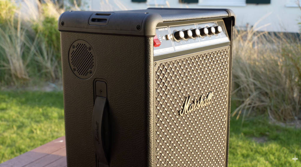 Marshall Bromley 450 Party-Lautsprecher mit schwarzem Lederlook, goldenen Akzenten und klassischer Verstärker-Optik im sonnigen Außenbereich.