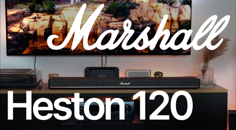 Eine schwarze Marshall Heston 120 steht unter dem Fernseher in einem Wohnzimmer mit Konsole, Verstärker und warmem Ambientelicht.