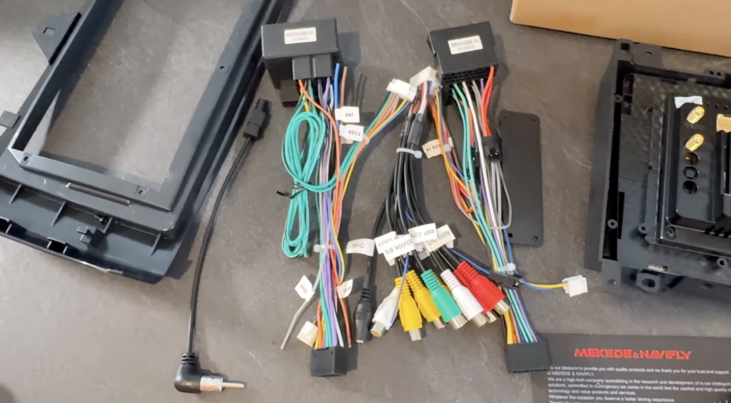 Mehrere Kabelbäume, Adapterstecker und Blenden liegen für den Einbau eines Android-Autoradios in die Mercedes B-Klasse von Camecho bereit.