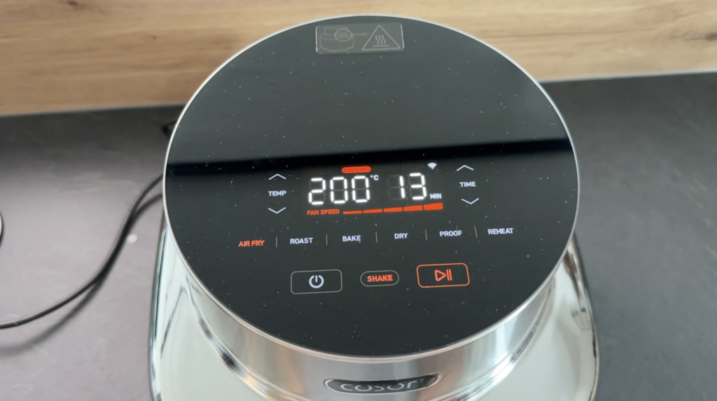Die COSORI ICONIC Single zeigt ihre schwarze Glasoberfläche mit 200 °C und 13 Minuten im Display sowie die Programme Air Fry, Roast und Bake.