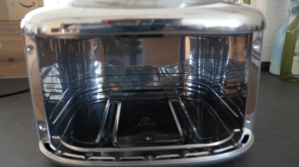Im geöffneten COSORI ICONIC Single zeigt sich ein glänzender Edelstahl-Airfryer mit dunklem Innenraum und sauberer, spiegelnder Oberfläche.
